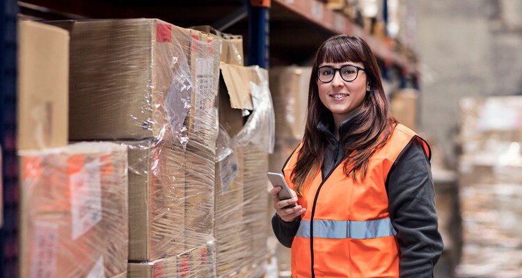 Mitarbeiterin der Logistik vor großem Regal mit Lagerbeständen